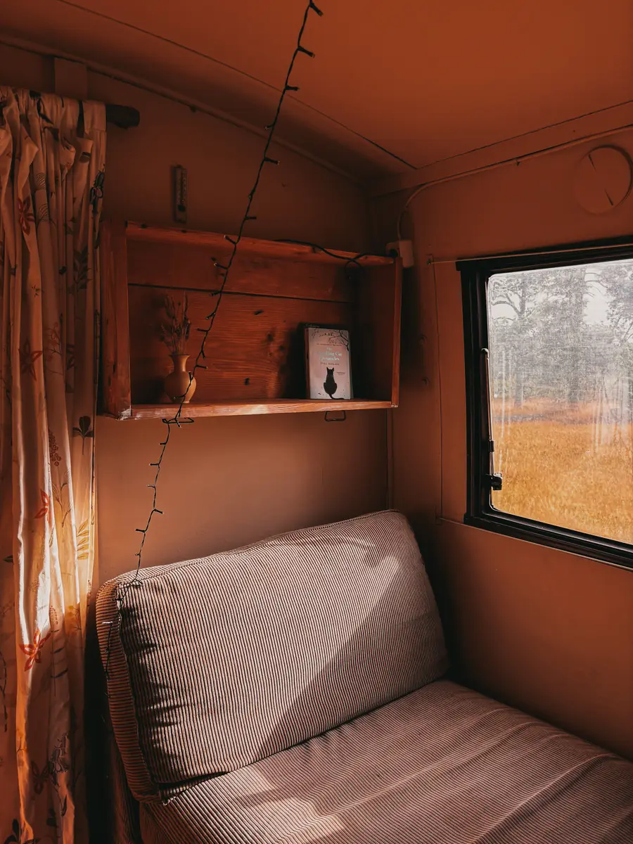 Inside, a bench under the window and the fields beyond it