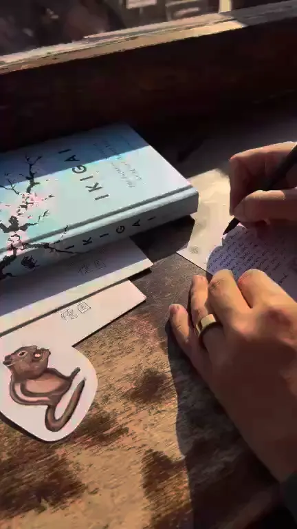 Painting a squirrel onto a card at a window above the rooftops