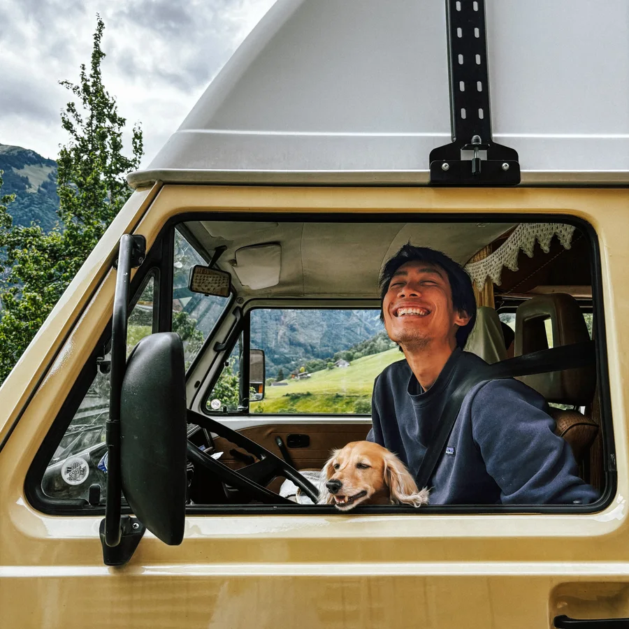 Frank laughing in the driver's window with a golden retriever