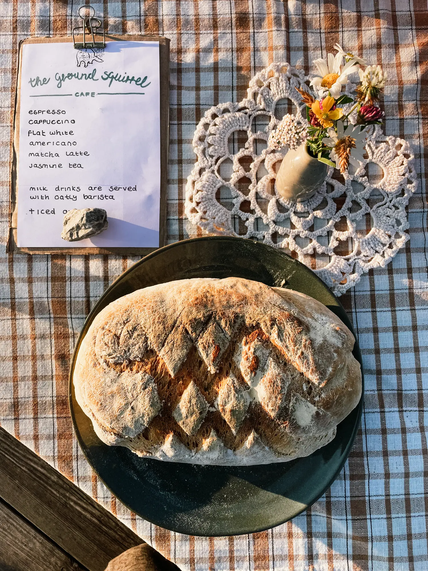 a loaf of bread fresh out of the oven, next to the café menu