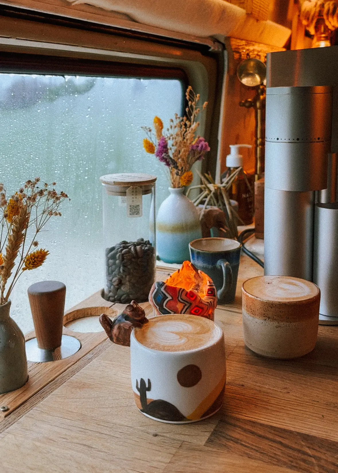 two coffees against a rained-on window