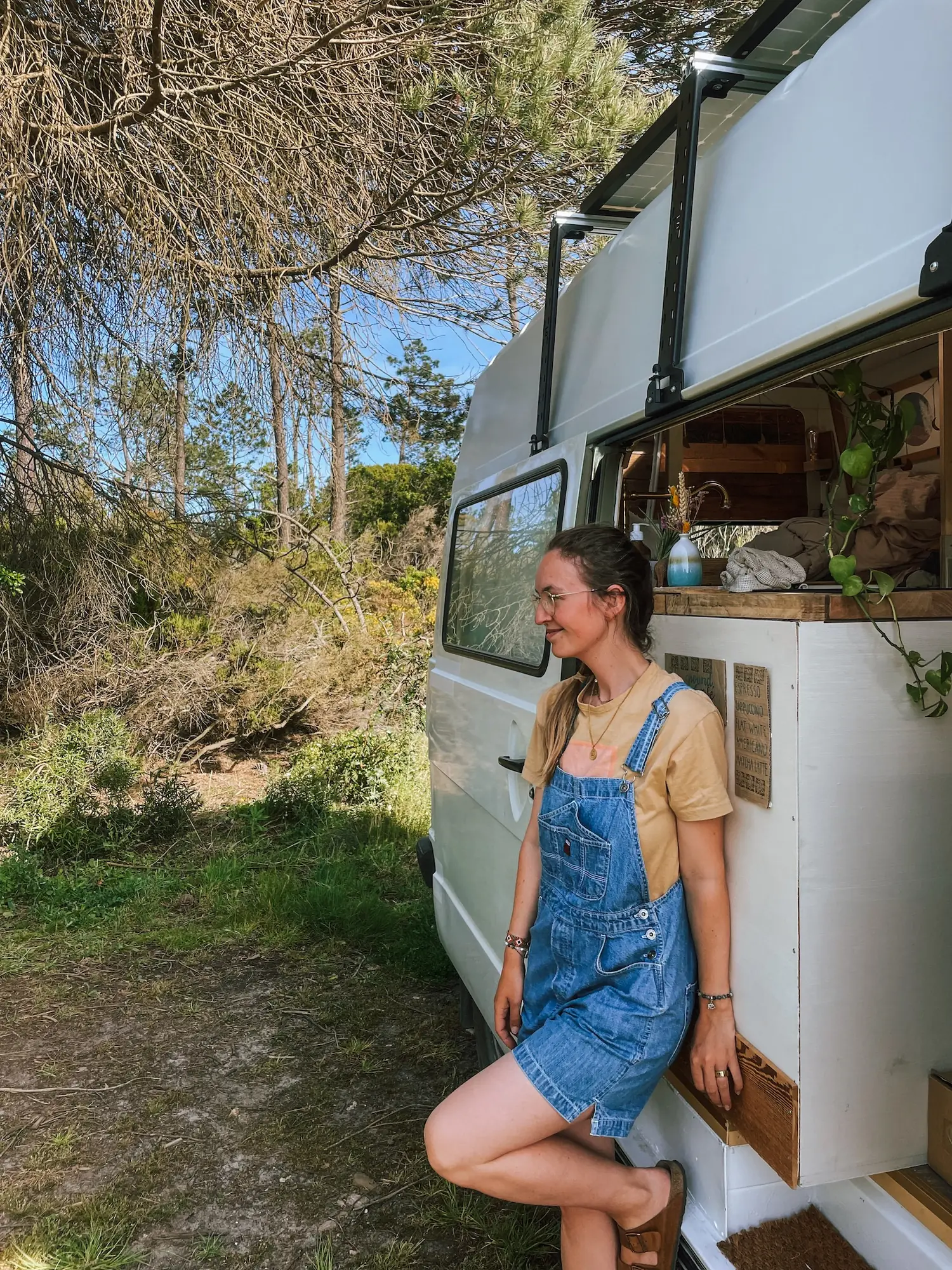 evelyne leaning against humbär among the pines