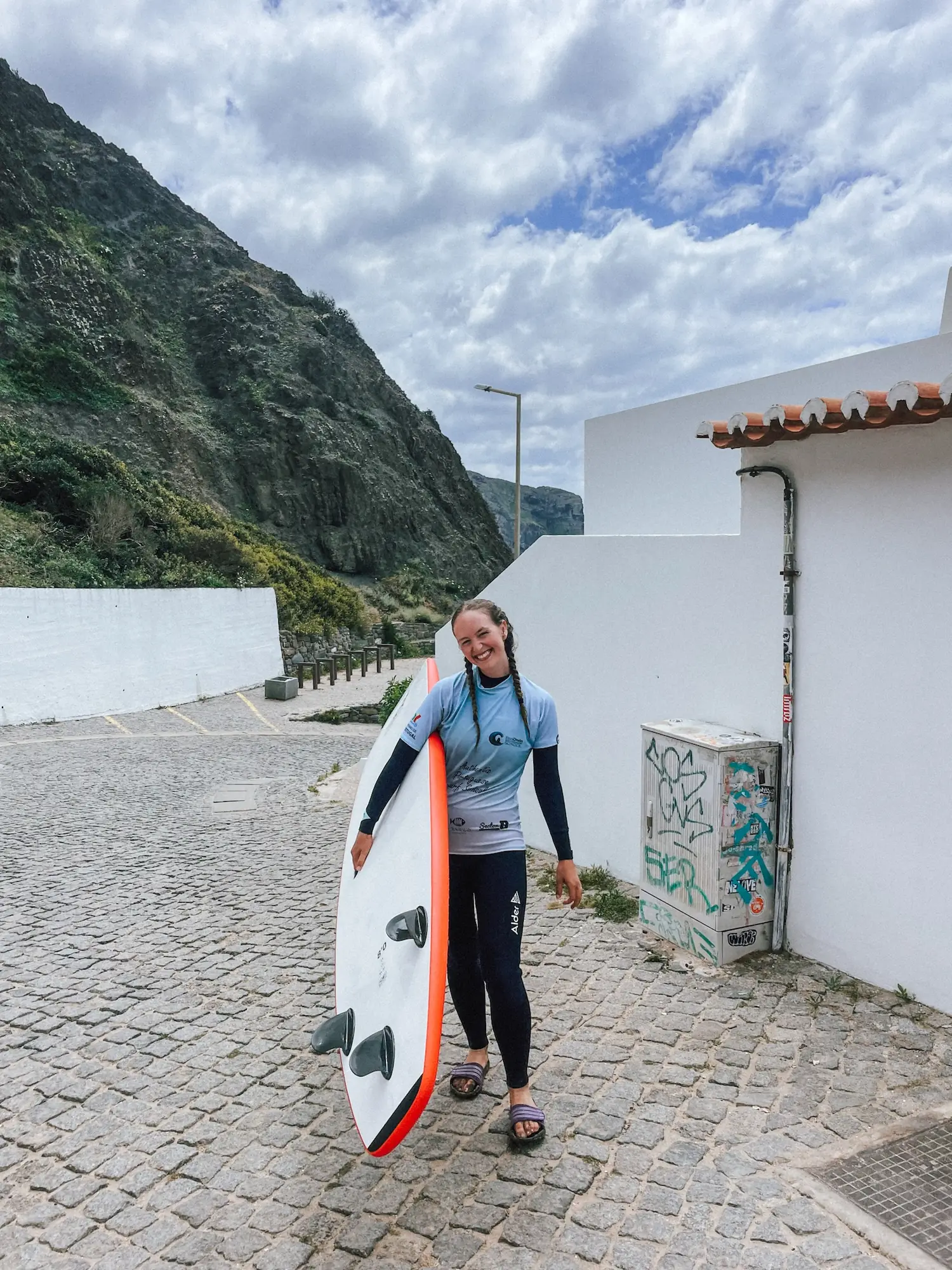 evelyne carrying a surfboard