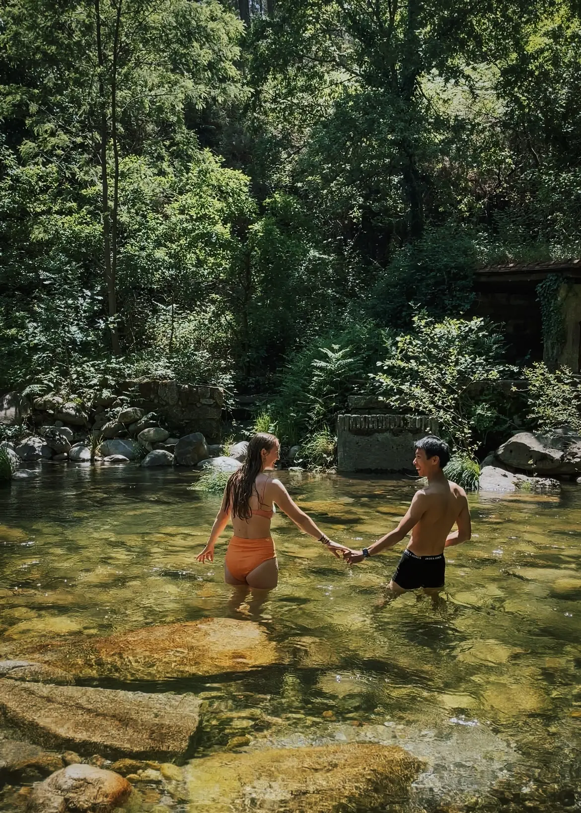 frank and evelyne in a natural pool in the forest