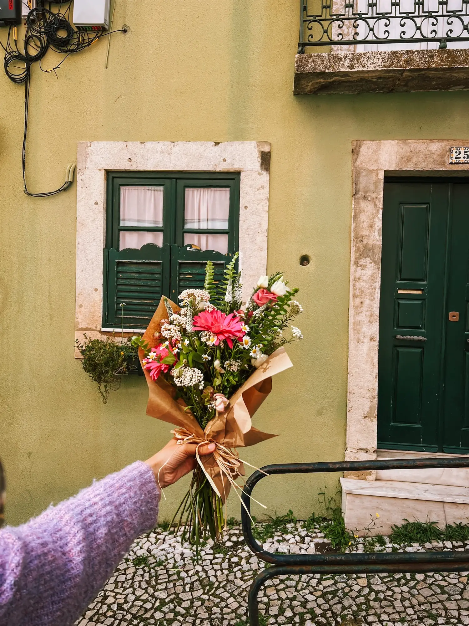 a bouquet of flowers in front of a lisbon house