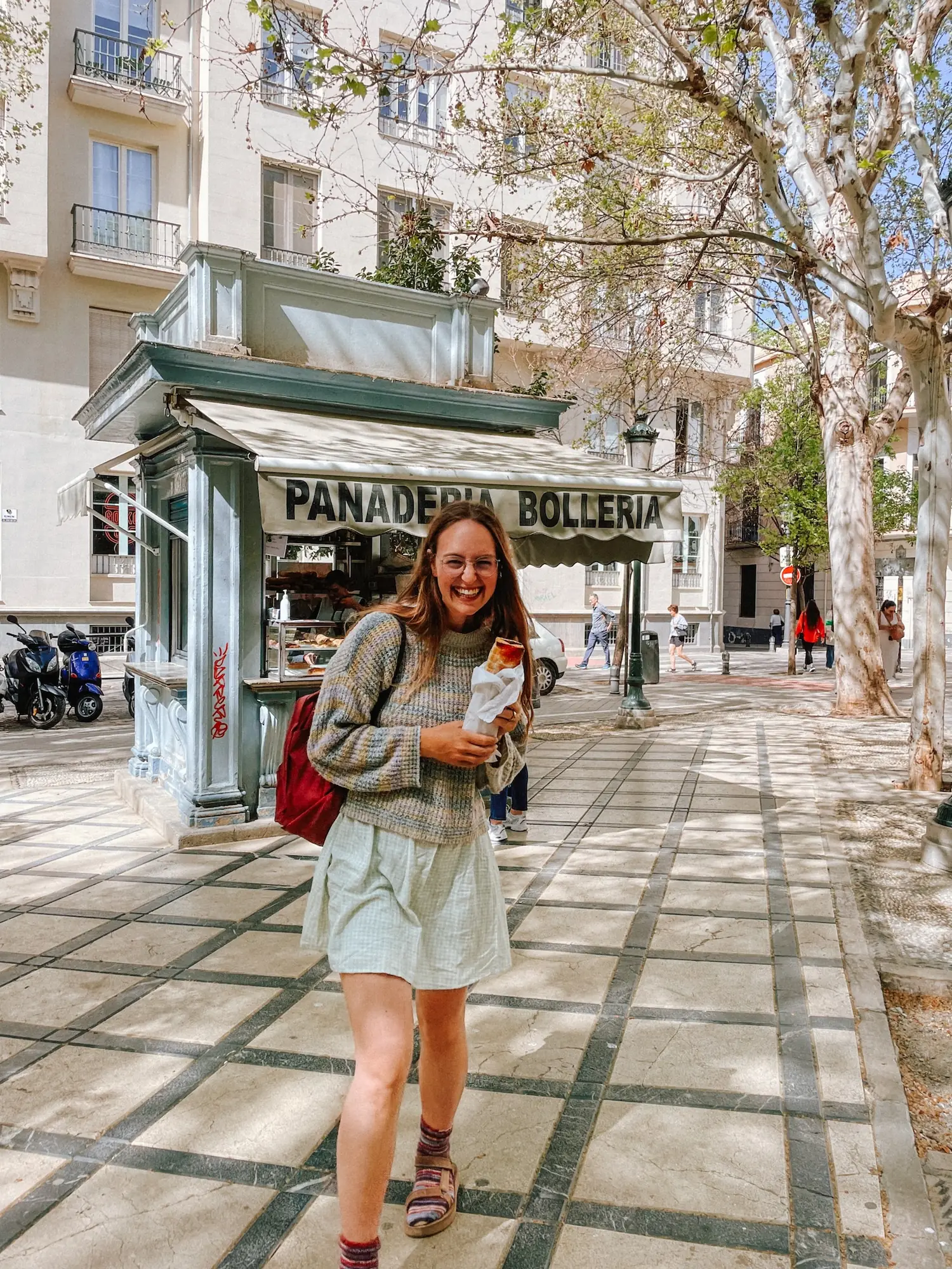 evelyne with a loaf of bread outside a bakery kiosk