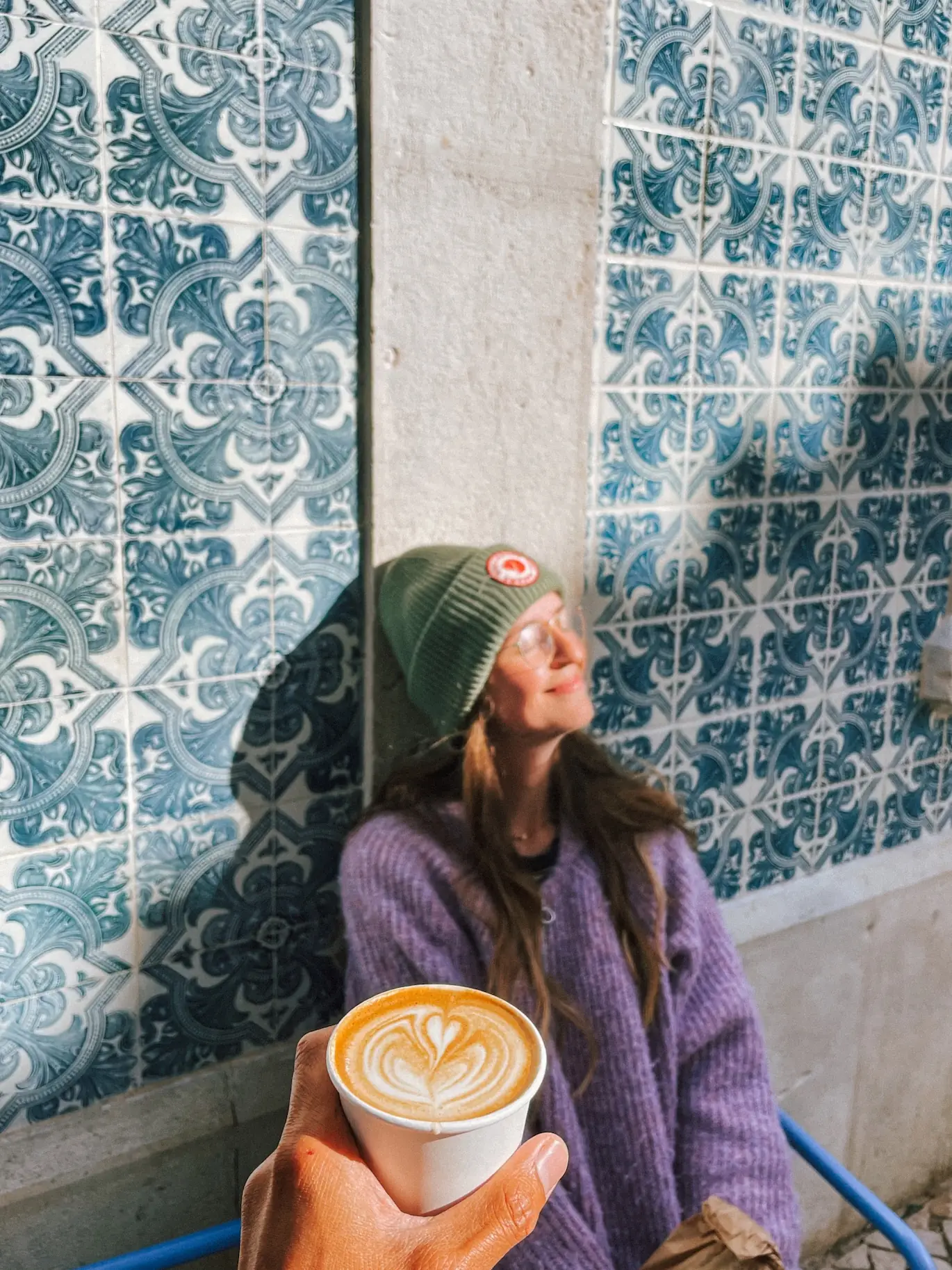 evelyne with a coffee in front of blue azulejos