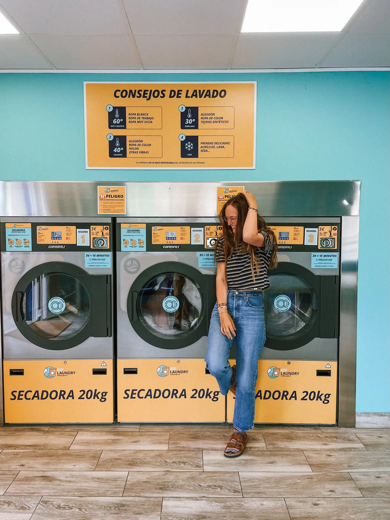 evelyne leaning on the dryers in a laundromat