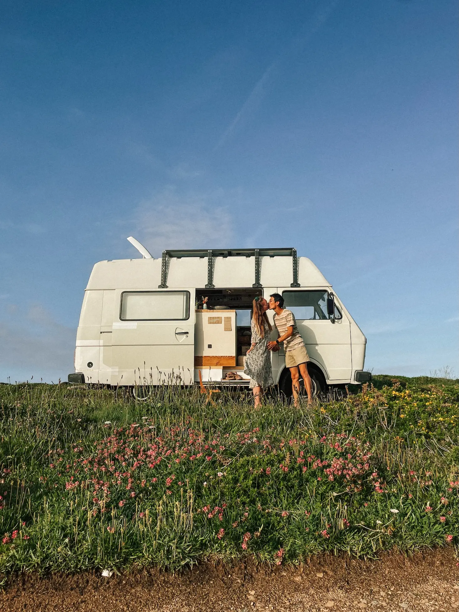 frank and evelyne kissing next to humbär in a flowering meadow