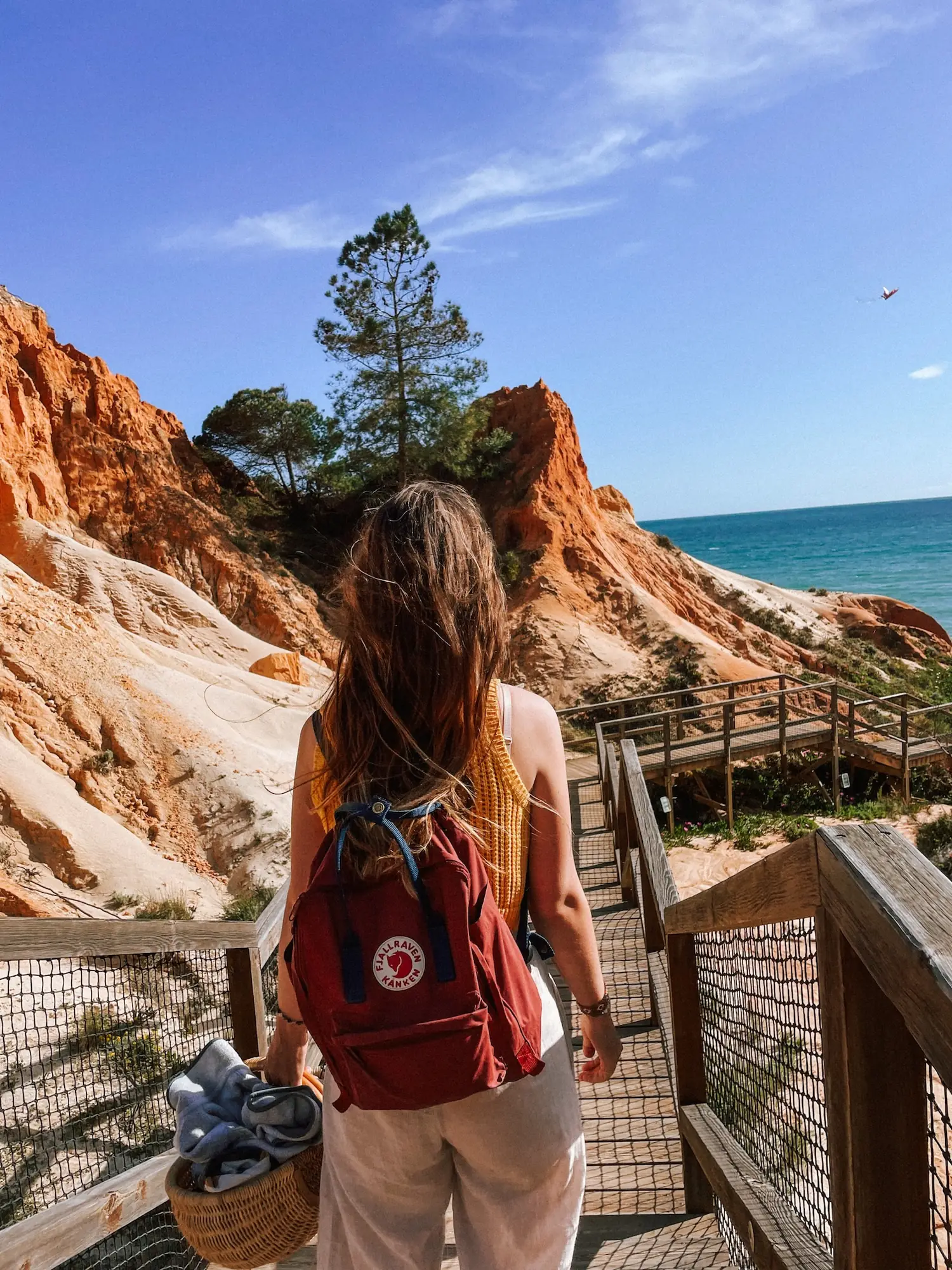 evelyne walking down a boardwalk between red cliffs