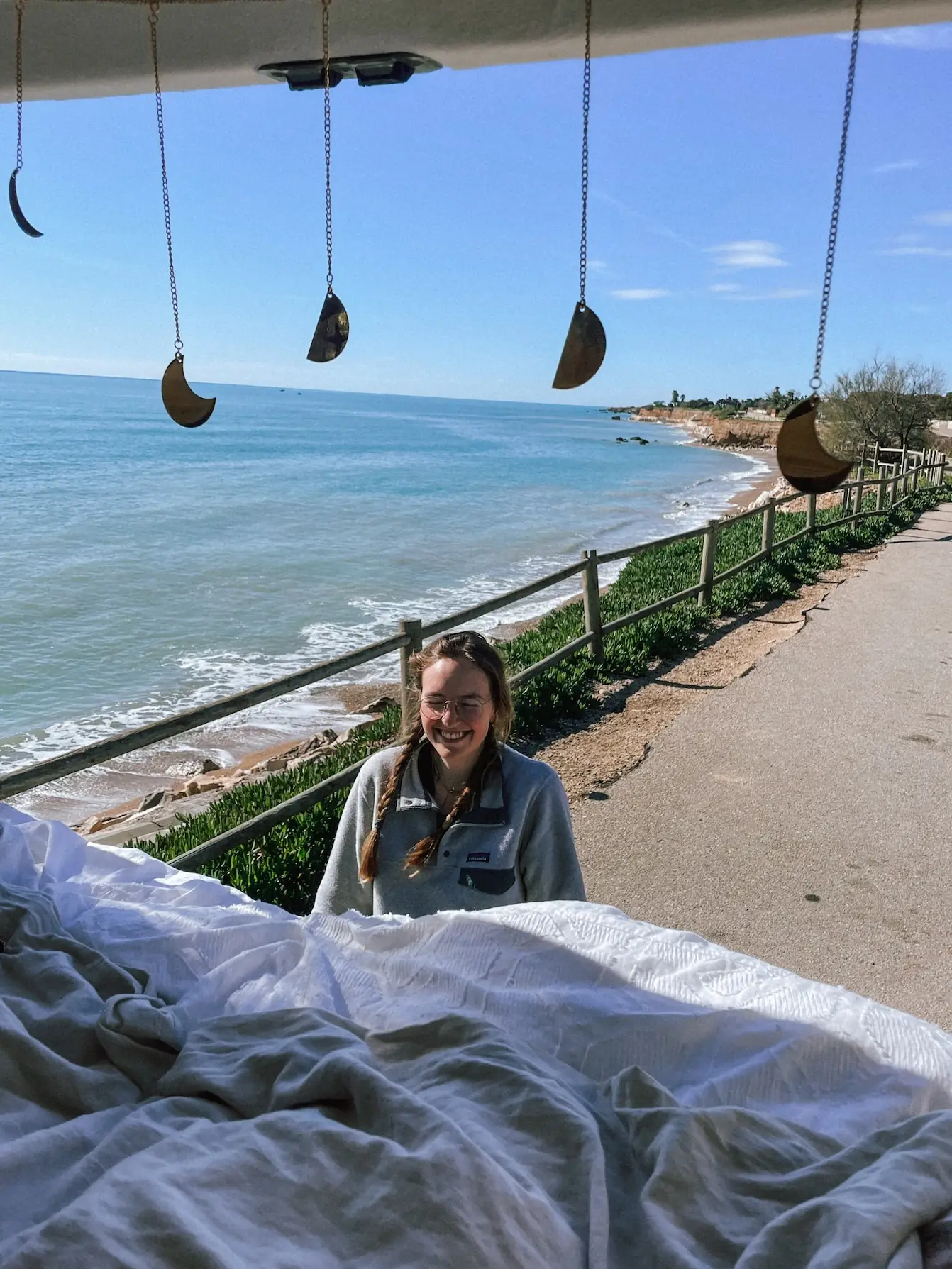 evelyne in bed in the van looking out at the sea