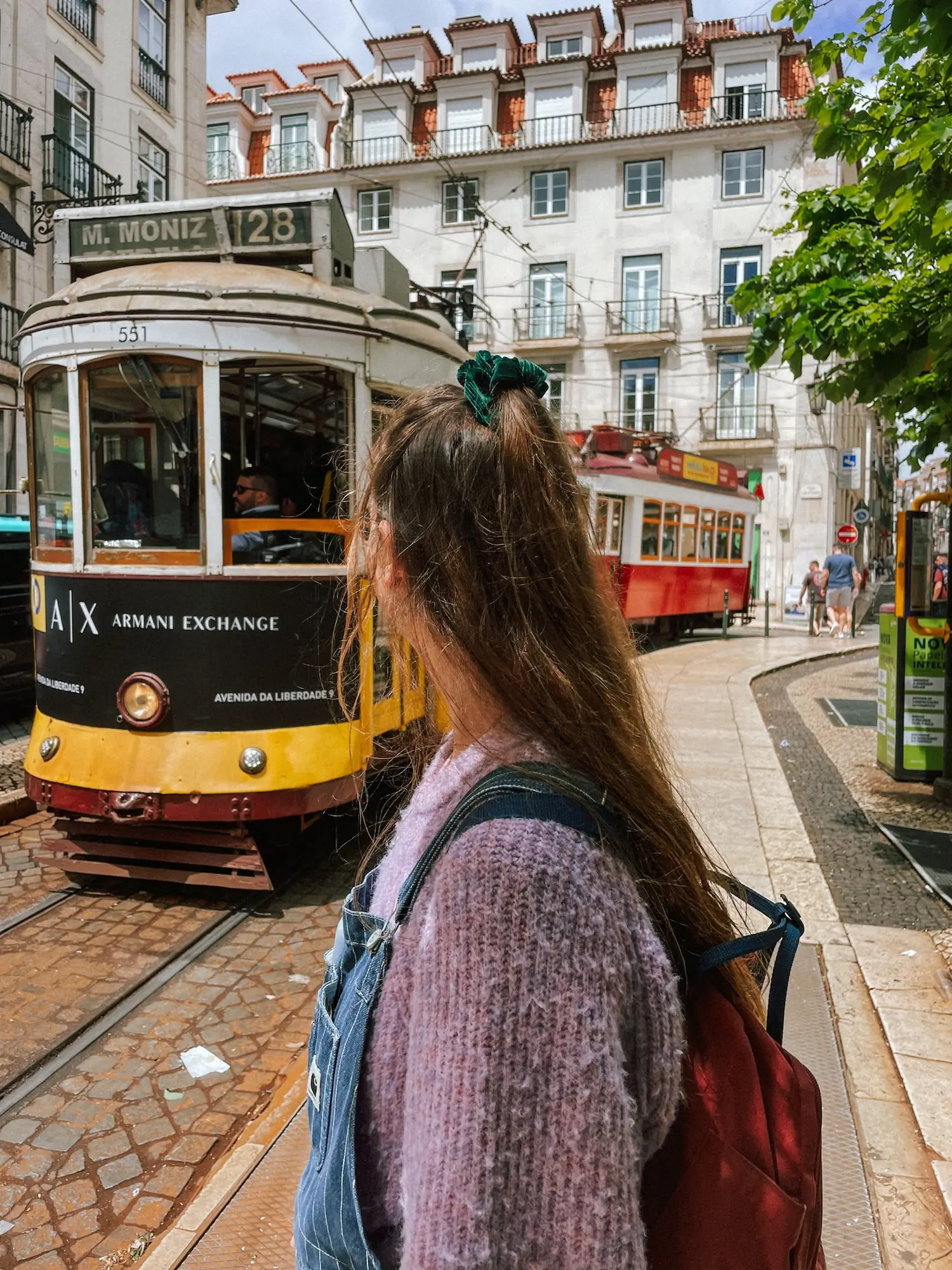 evelyne next to a yellow tram in lisbon
