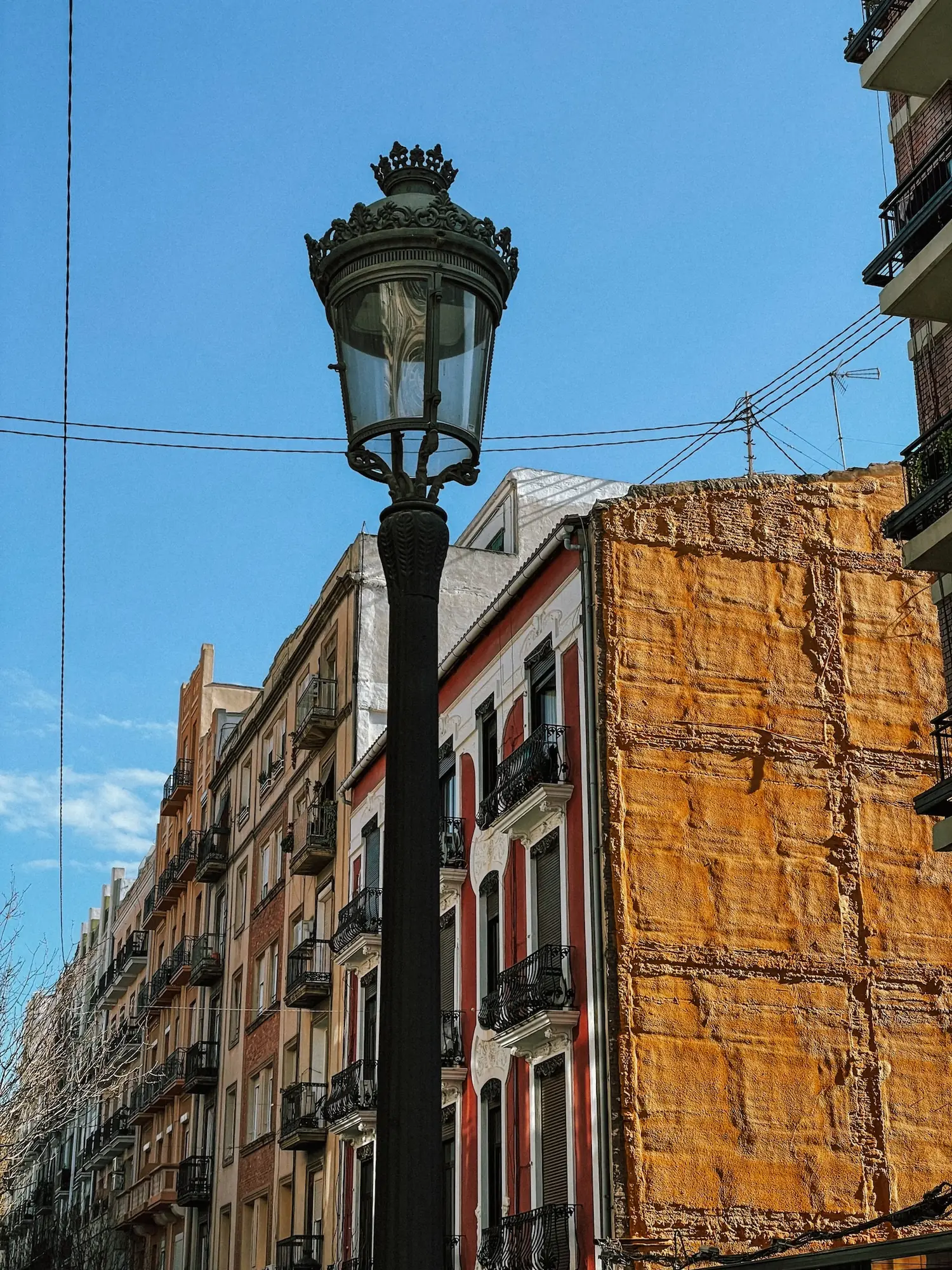a street lamp in front of old buildings in valencia