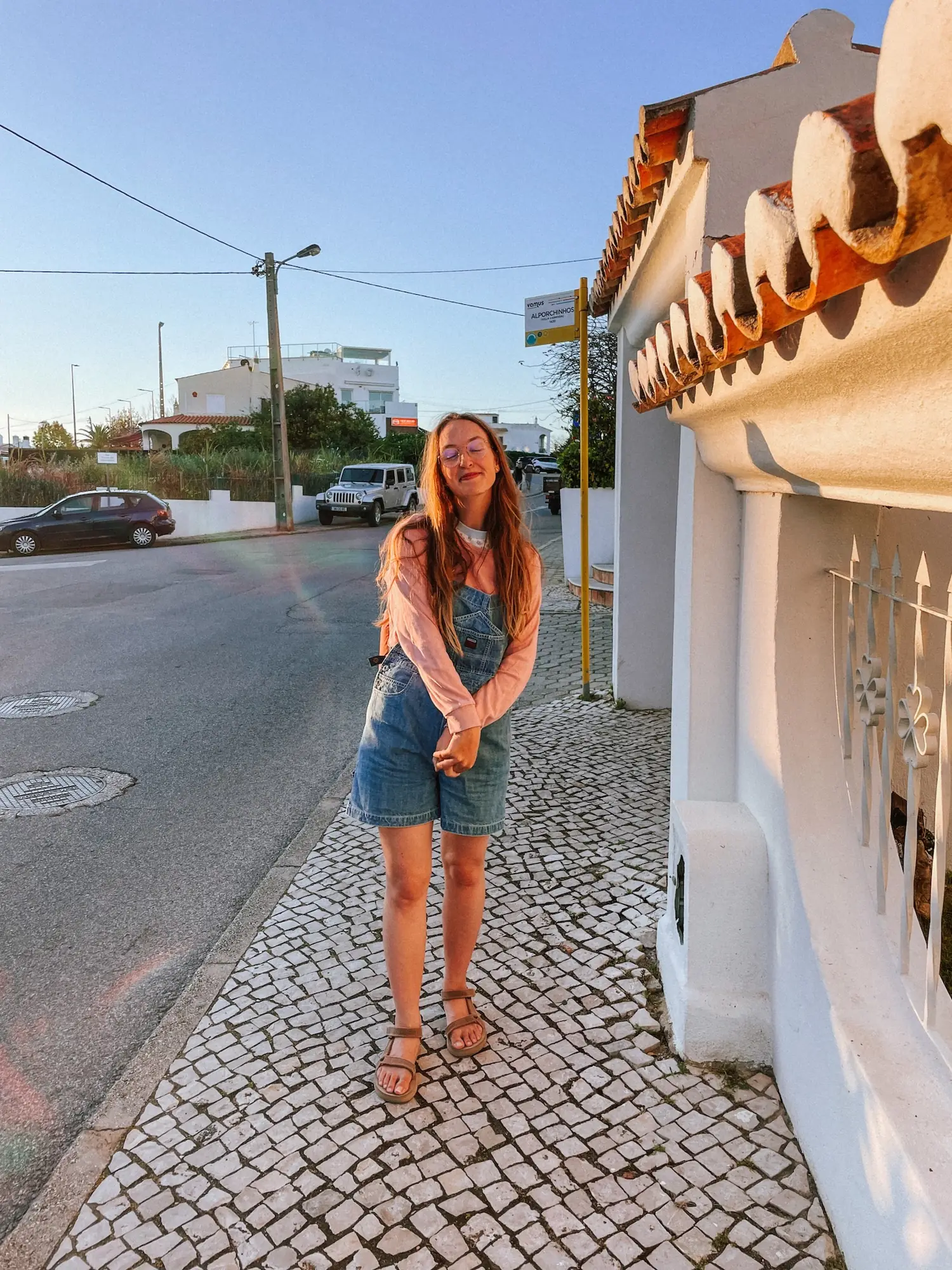evelyne waiting at a bus stop