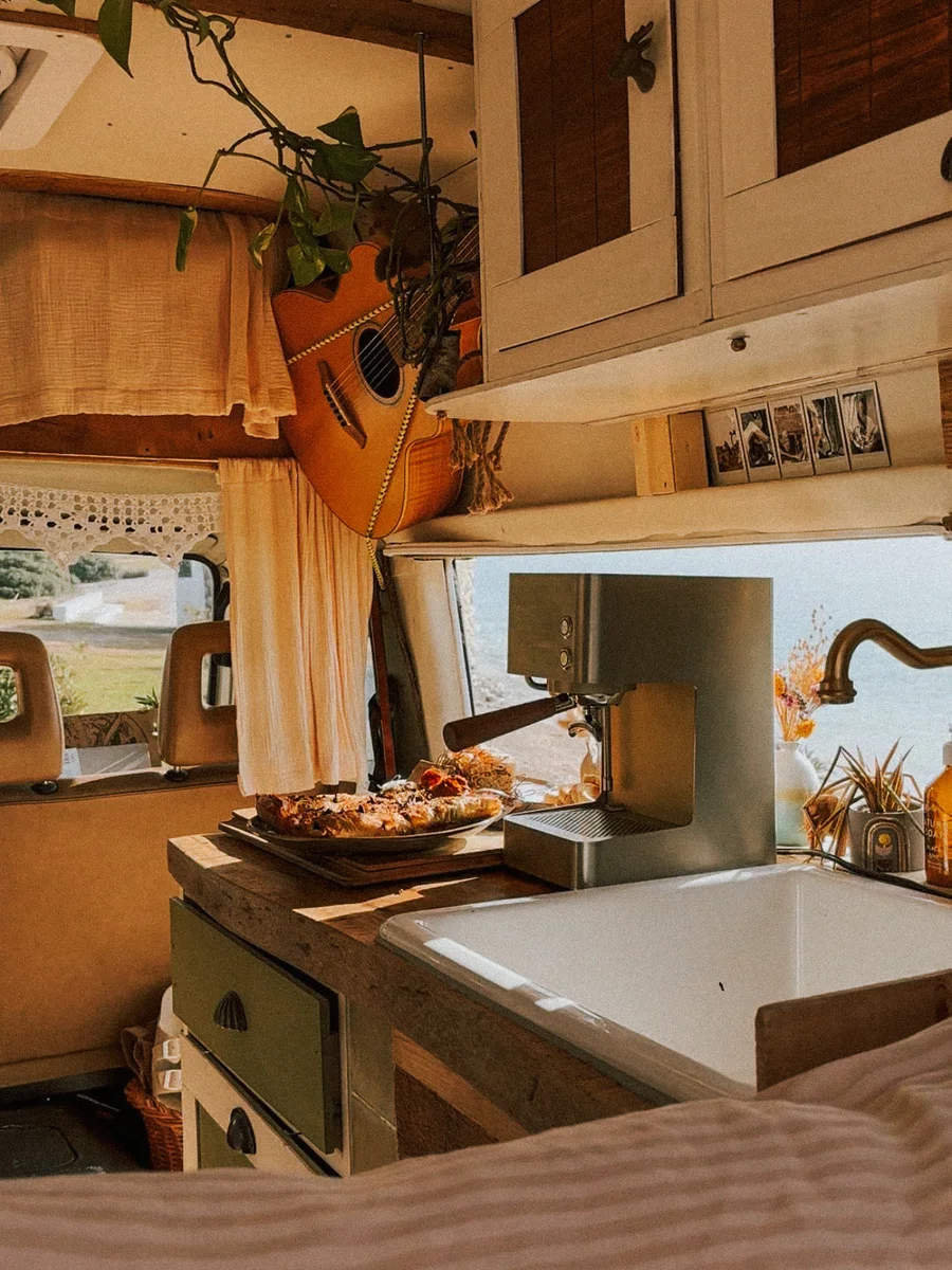 The espresso machine and a tray of pastries inside the camper