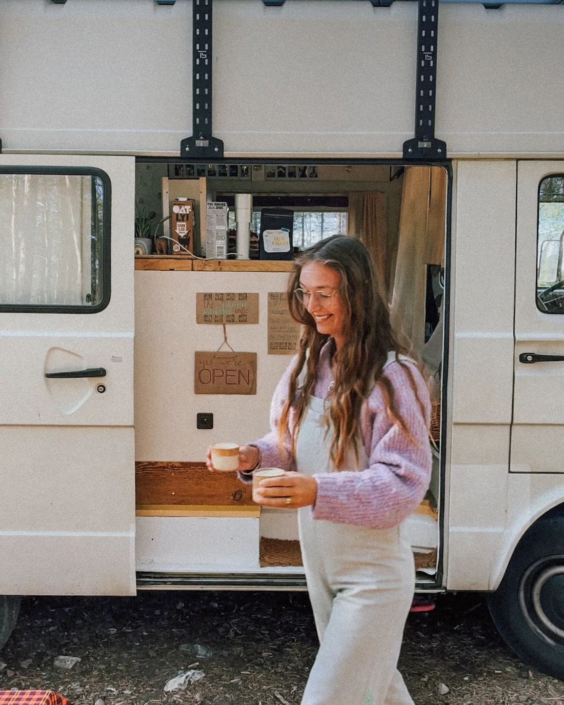 Humbär parked in the forest with the café hatch open and coffee being carried out